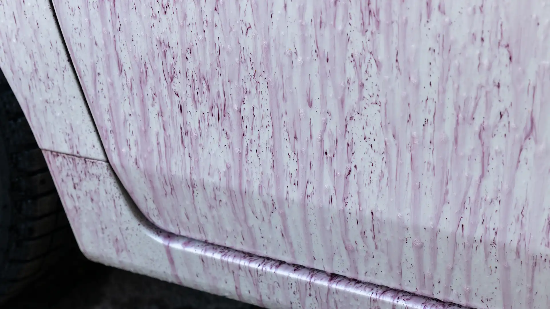 鉄粉除去用の薬剤を散布して紫色に変色した車両の下部の画像
